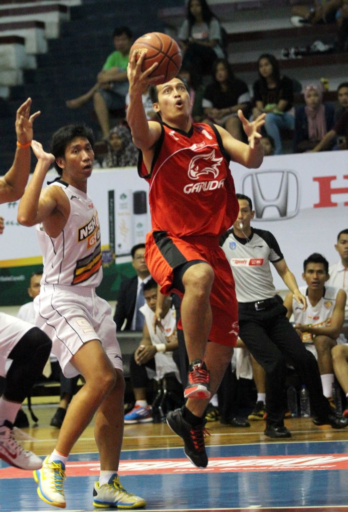 Shooting guard Garuda Kukar Bandung Diftha Pratama (kanan) melakukan layup dalam laga melawan NSH GMC GSBC Jakarta, Jumat (16/1).