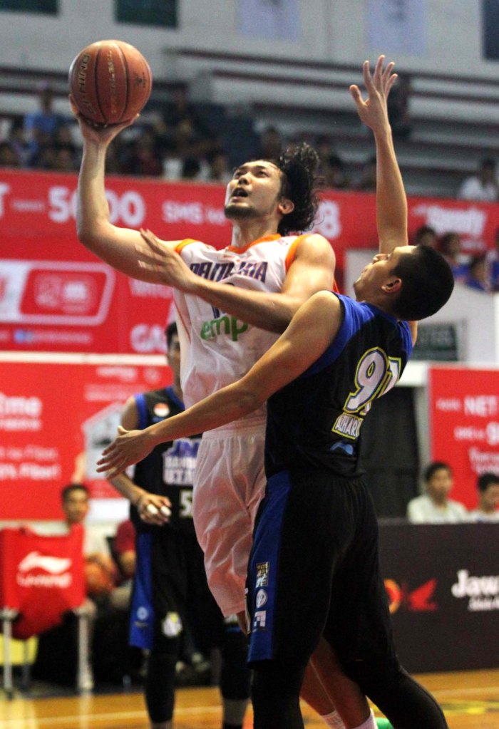 Power forward Pelita Jaya Energi Mega Persada Jakarta Ponsianus Nyoman Indrawan (kiri) dijaga Azhari Rahmat (JNE BSC Bandung Utama) saat berlaga di GOR Bimasakti, Malang, Sabtu (17/1). 