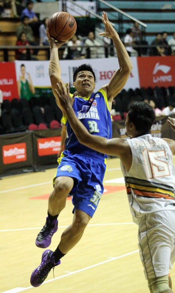 Power forward JNE BSC Bandung Utama Luke Martinus (kiri) mencoba melepaskan tembakan dalam laga melawan NSH GMC GSBC Jakarta, Kamis (23/1).
