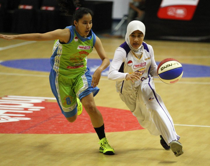 Shooting guard Surabaya Fever Raisa Aribatul Hamidah (kanan) memimpin perolehan angka dalam laga melawan Sritex Dragons Enduro Solo di DBL Arena Surabaya, Minggu (25/1).​