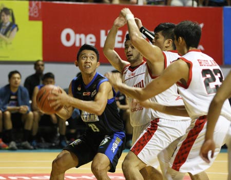 Point guard JNE BSC Bandung Utama Gian Gumilar (kiri) dihadang beberapa pemain Stadium Jakarta dalam laga di DBL Arena Surabaya, Minggu (25/1). (Foto: Boy Slamet/Jawa Pos)
