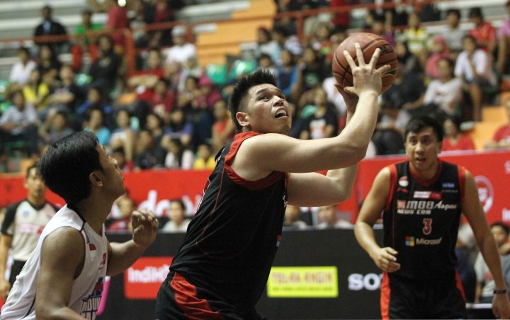 Center M88 Aspac Jakarta Ferdinand Damanik (tengah) berusaha melepaskan tembakan setelah melakukan offensive rebound dalam laga melawan JNE BSC Bandung Utama di Sritex Arena, Solo, Jumat (27/2).
