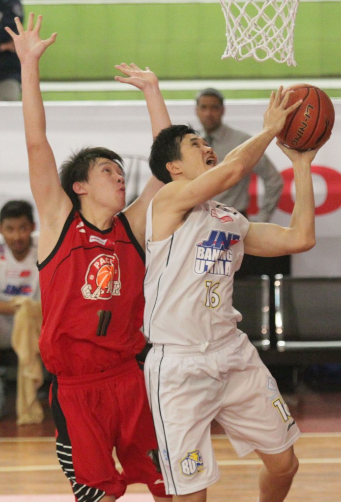 Power forward JNE BSC Bandung Utama Andre Tiara (kanan) dan Ferry Lieviandy (Pacific Caesar Surabaya) dalam laga di GOR Sahabat, Semarang, Rabu (4/3).