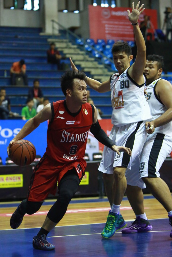 Small forward Stadium Jakarta Wijaya Saputra (kiri) melewati hadangan Mei Joni (Hangtuah Sumsel IM) dalam lanjutan IndiHome NBL Indonesia 2014-2015 di C-Tra Arena, Bandung, Kamis (26/3).