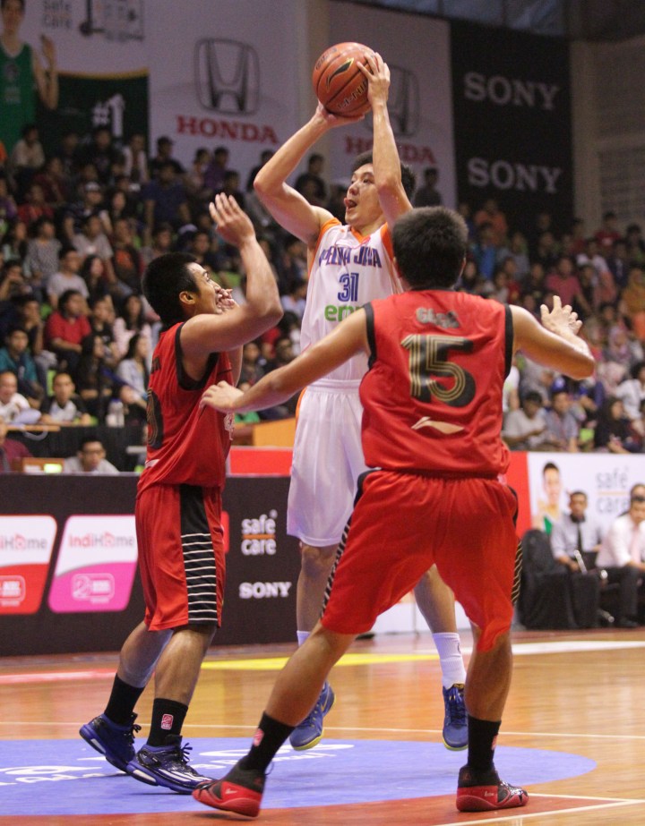 Small forward Pelita Jaya Energi Mega Persada Jakarta Hendru Ramli (tengah) melepaskan tembakan dihadang Dicky Satria Wibisono (kiri) dan Gege Nagata dari Pacific Caesar dalam laga di GOR Sahabat, Semarang, Sabtu (7/3).