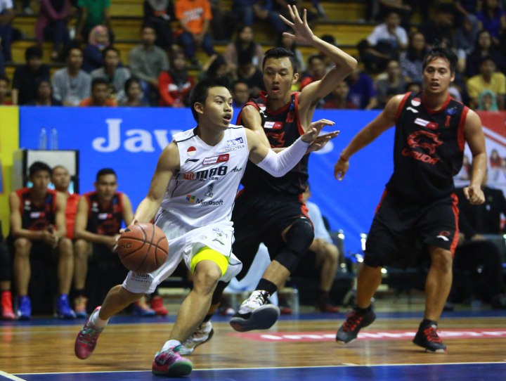 Point guard M88 Aspac Jakart Andakara Prastawa Dhyaksa (kiri) dijaga Muhammad Rizal Falconi dan Diftha Pratama dari Garuda Kukar Bandung dalam laga di C-Tra Arena, Bandung, Sabtu (28/3)