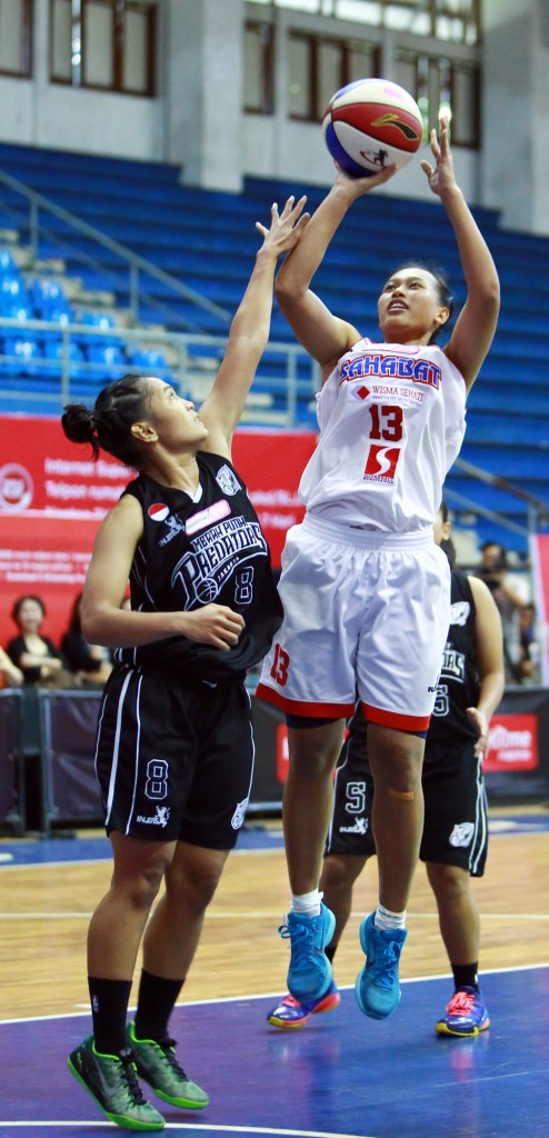 Power forwad Sahabat Wisma Sehati Semarang Yuni Anggraeni melepaskan tembakan dijaga oleh Fitryana Sari Dewi (Merah Putih Predators) dalam laga di C-Tra arena, Bandung (29/03)