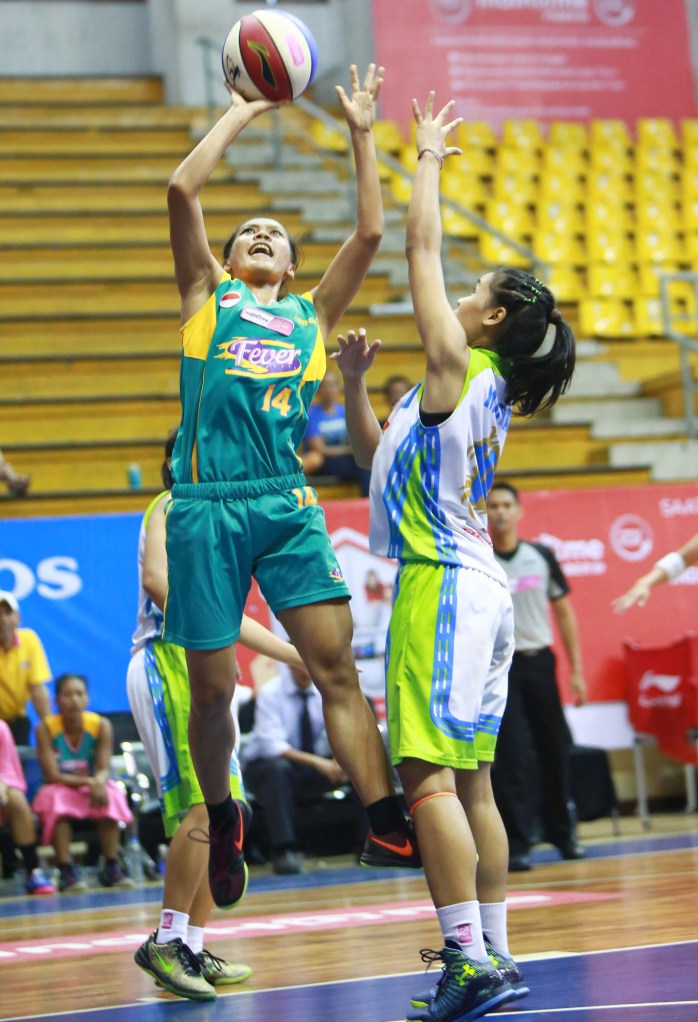 Power forward Surabaya Fever Mega Nanda Perdana Putri (kiri) melepaskan tembakan dijaga Lophy Mora Christya (Sritex Dragons Solo) di C-Tra Arena, Bandung, Sabtu (28/03).