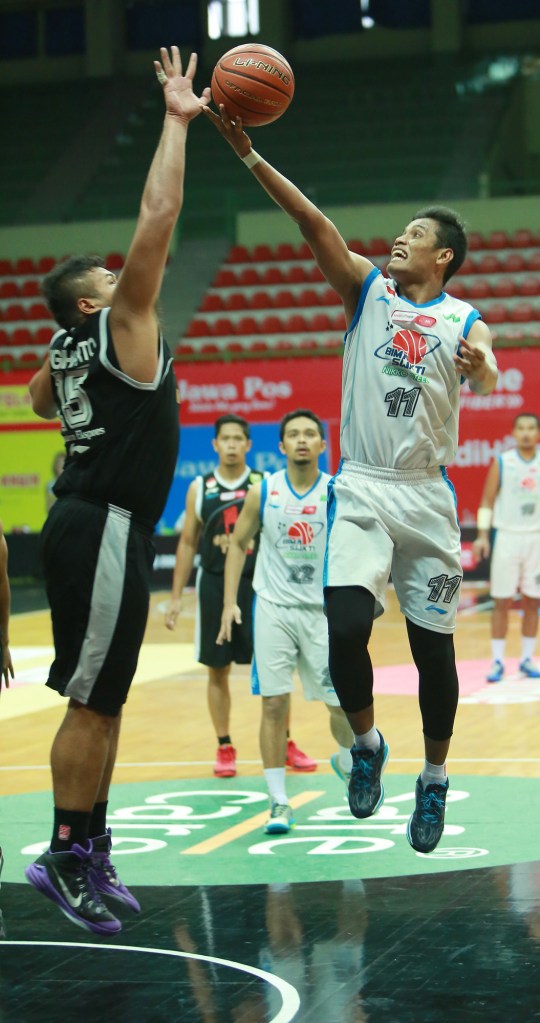 Shooting guard Bimasakti Nikko Steel Malang M. Alan As'adi (kanan) melakukan lay up dijaga oleh Toni Sugiharto  dari Hangtuah Sumsel IM dalam laga di GOR UNY, Jogjakarta (12/03/2015)