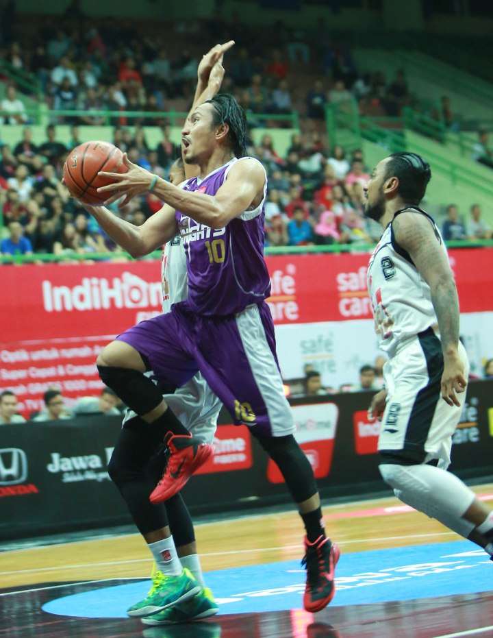 Small forward CLS Knights Surabaya Rachmad Febri Utomo (kiri) melakukan lay up dalam laga melawan Hangtuah Sumsel di GOR UNY, Jogjakarta, Rabu (11/3).