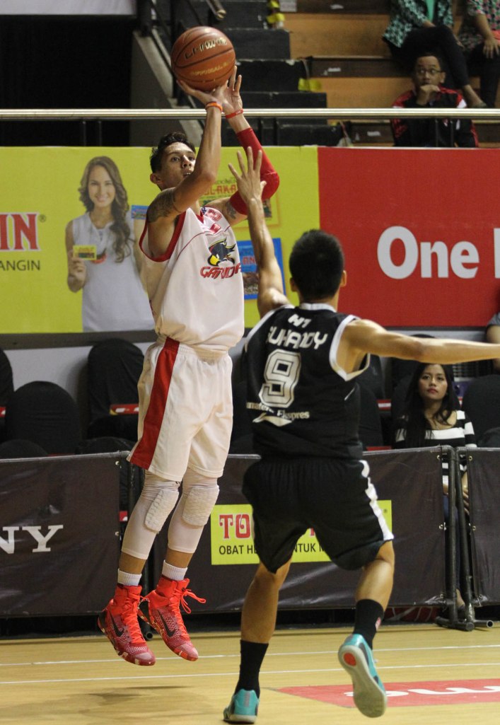 Small forward Garuda Kukar Bandung Daniel Timothy Wenas (kiri) melepaskan tembakan dihadang Suhandy (Hangtuah Sumsel IM) dalam laga di DBL Arena, Surabaya, Rabu (8/4).