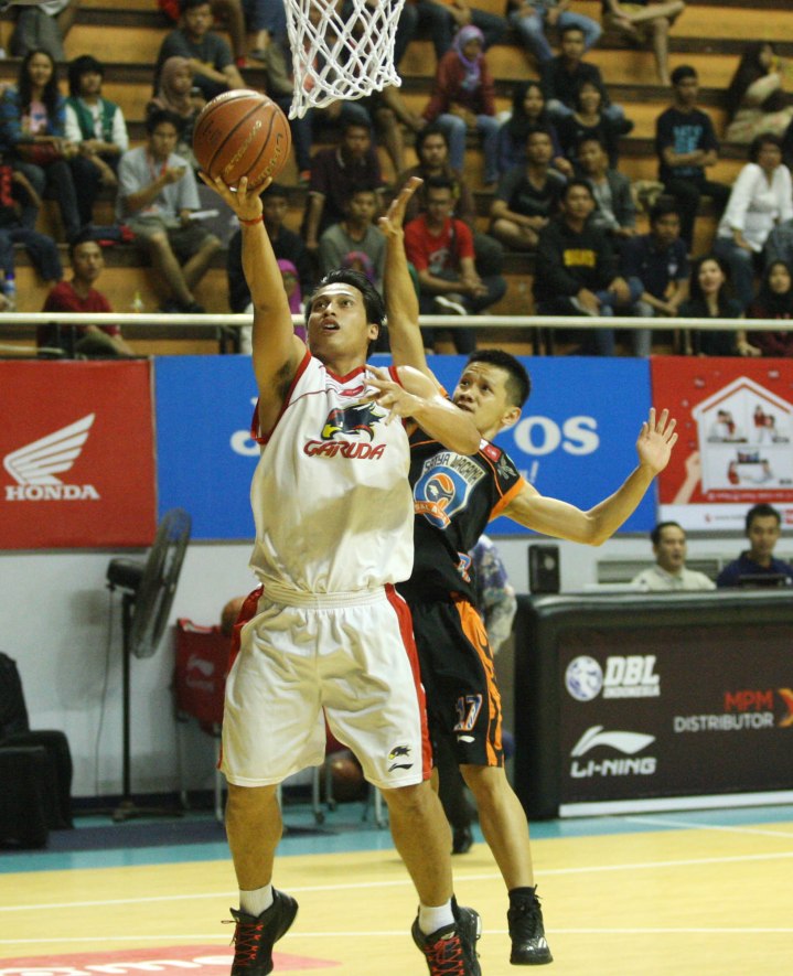 Shooting guard Garuda Kukar Bandung Diftha Pratama (kiri) melepaskan layup dibawah penjagaan Budi Sucipto (Satya Wacana ACA LBC Salatiga) dalam laga di DBL Arena, Surabaya, Jumat (10/4).