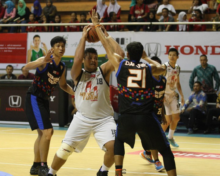 Center Hangtuah Sumsel IM Toni Sugiharto (tengah) berusaha melewati penjagaan Raylly Pratama (kiri) dan Boy Elimar Damanik dari NSH GMC GSBC Jakarta dalam laga di DBL Arena, Surabaya, Jumat (10/4).