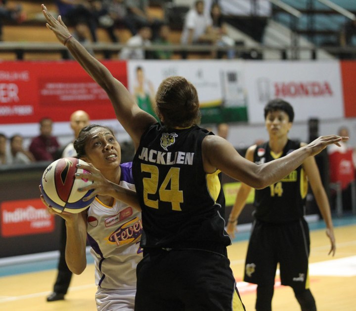 Center Surabaya Fever Gabriel Sophia (kiri) berusaha melepaskan tembakan melewati hadangan Jacklien Ibo dari Tomang Sakti Mighty Bees Jakarta dalam laga di DBL Arena, Surabaya, Kamis (9/4).