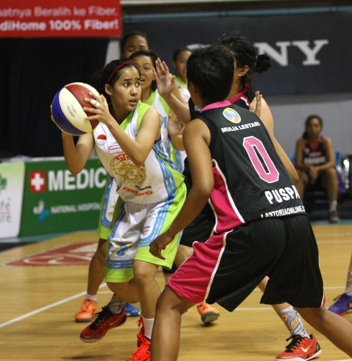 Small forward Sritex Dragons Solo Tania Rasidi (kiri) dihadang Puspa Lalita Anggayasti dari Rajawali Bandung dalam laga di DBL Arena, Surabaya, Kamis (9/4).