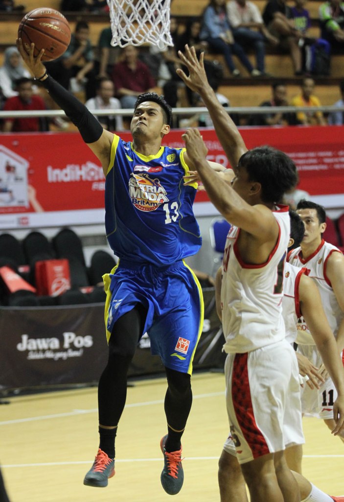 Shooting guard Satria Muda BritAma Jakarta Gunawan (kiri) melakukan lay up dalam laga melawan Stadium Jakarta di DBL Arena, Surabaya, Rabu (8/4).