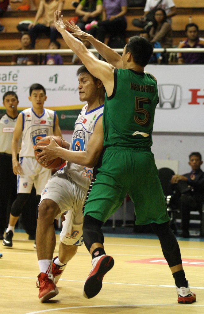 Center Satya Wacana ACA LBC Salatiga Firman Dwi Nugroho (kiri) berusaha menerobos pertahanan Dian Heryadi dari Pacific Caesar Surabaya dalam laga di DBL Arena, Surabaya, Minggu (12/4).