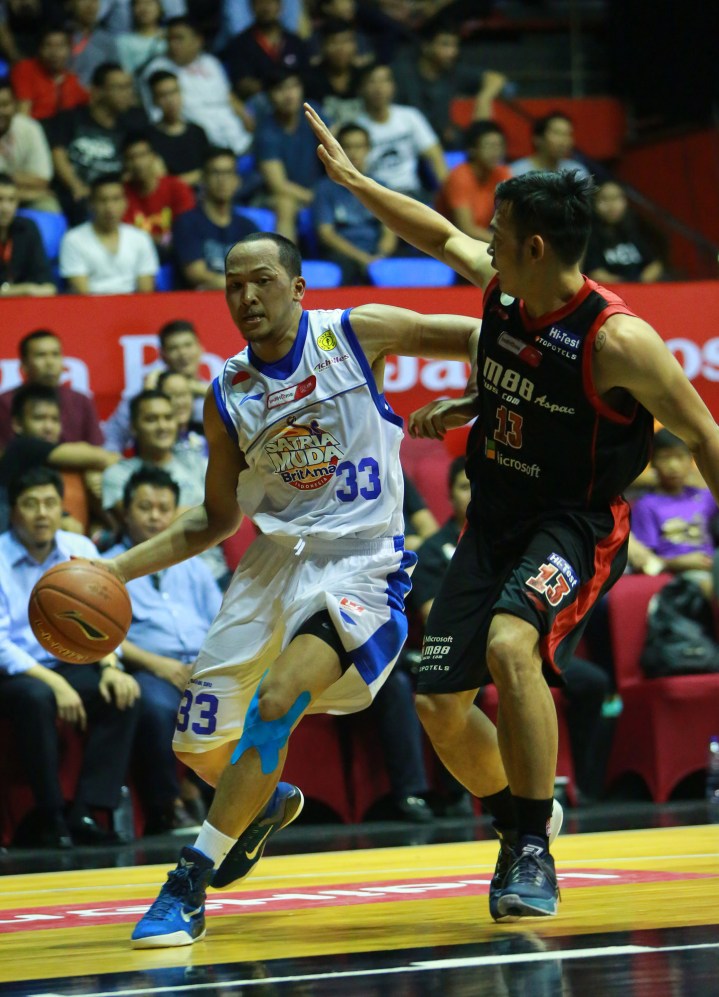 Small forward Satria Muda BritAma Jakarta Arki Dikania Wisnu di jaga oleh Ebrahim Enguio Lopez (M88 Aspac Jakarta) dalam IndiHome NBL Indonesia Championship Series di Hall Basket Senayan, Jakarta, Senin (04/05).