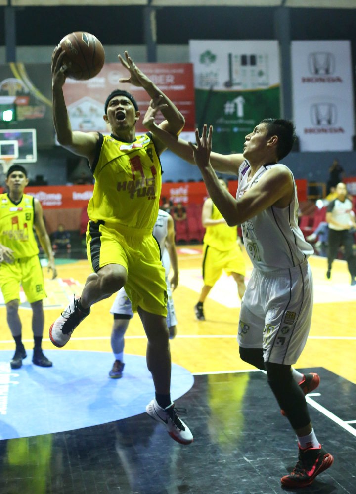 Shooting guard Hangtuah Sumsel IM Andre Ekayana (kiri) melakukan lay up melewati penjagaan Azhari Rahmat  dari JNE BSC Bandung Utama dalam laga di Hall Basket Senayan, Jakarta, Minggu (3/5).